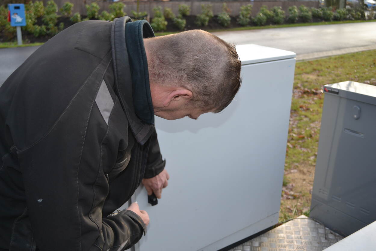 Man die op straat werkt aan een elektriciteitskast