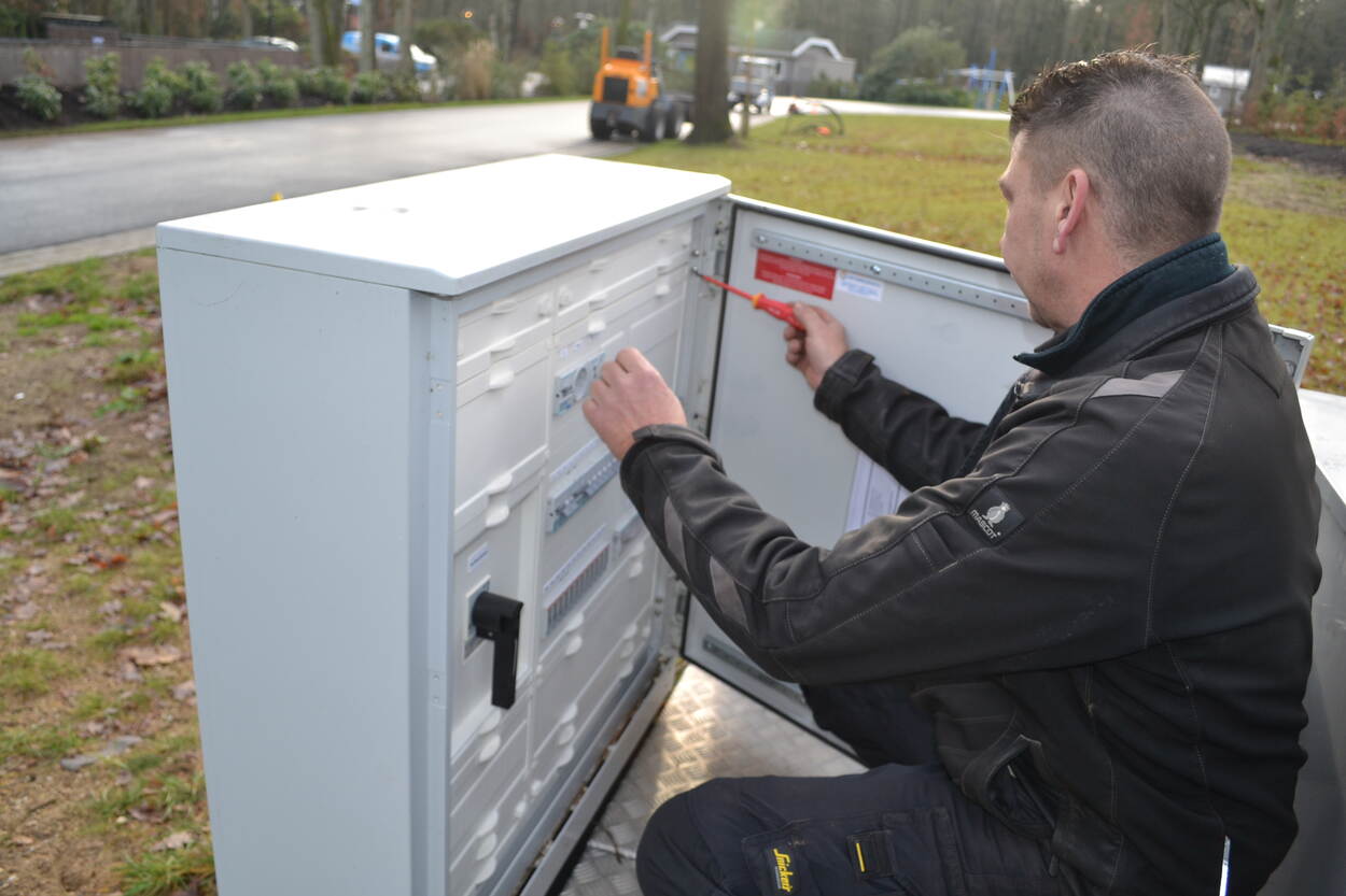 Man die op straat werkt aan een elektriciteitskast