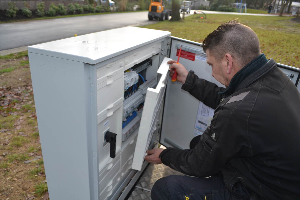 Man die op straat werkt aan een elektriciteitskast