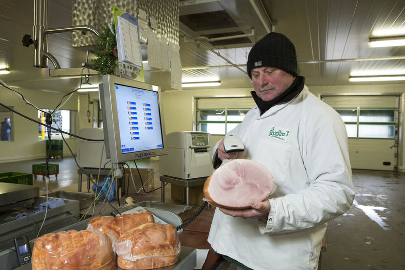 Een slager die een ham weegt