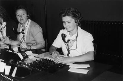Twee vrouwen achter een microfoon van vroeger