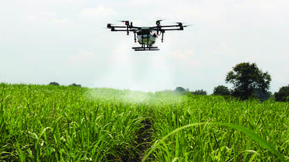 Drone die water verspreid over landbouwgrond met precisielandbouw