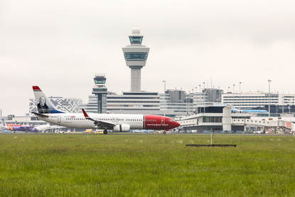 Meerdere vliegtuigen zijn geland op schiphol. Op de achtergrond de Luchtverkeersleiding Nederland vanuit de toren op Schiphol.