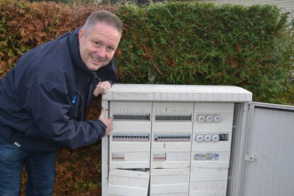 Man die op straat werkt aan een elektriciteitskast